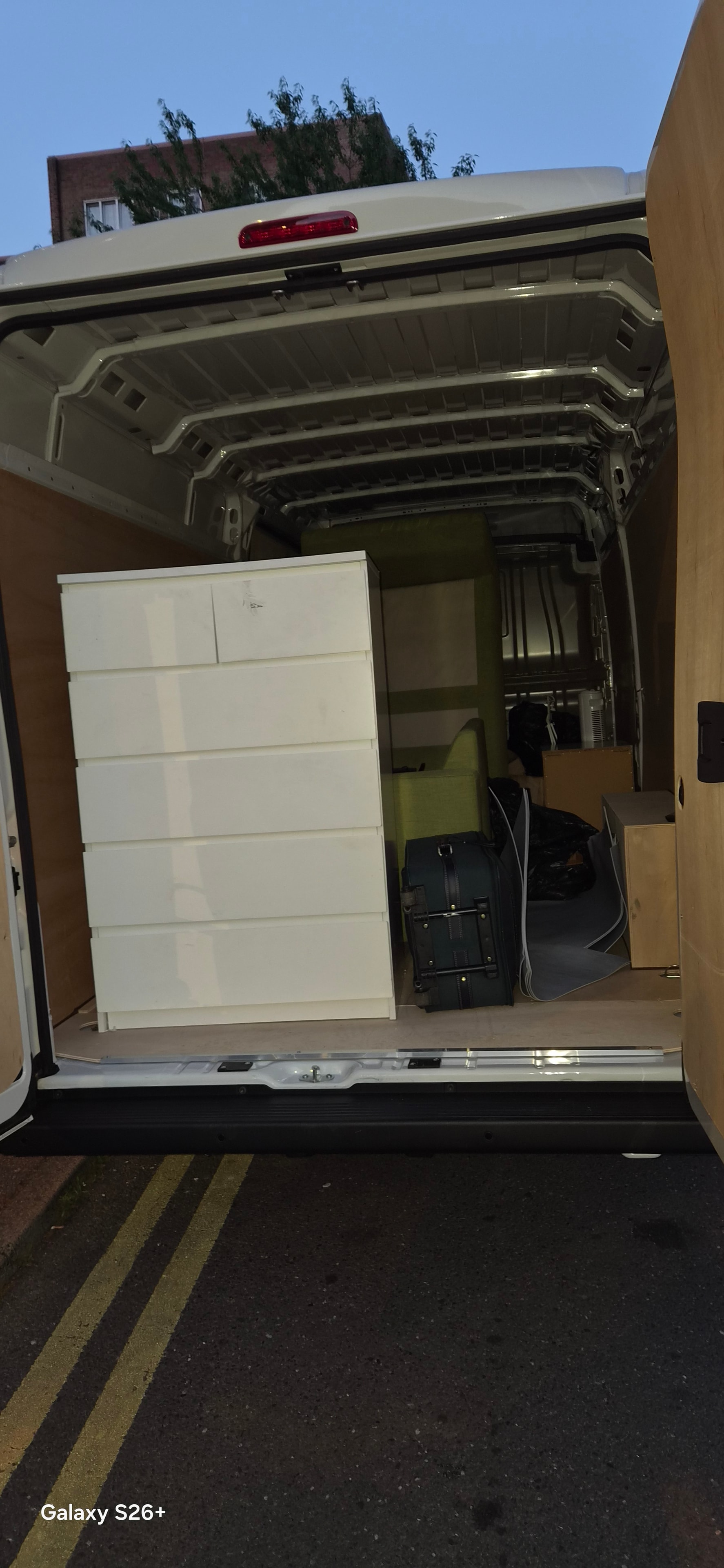 Van interior being loaded with items including a wardrobe